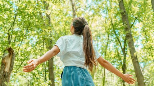 Tjej går runt i en skog